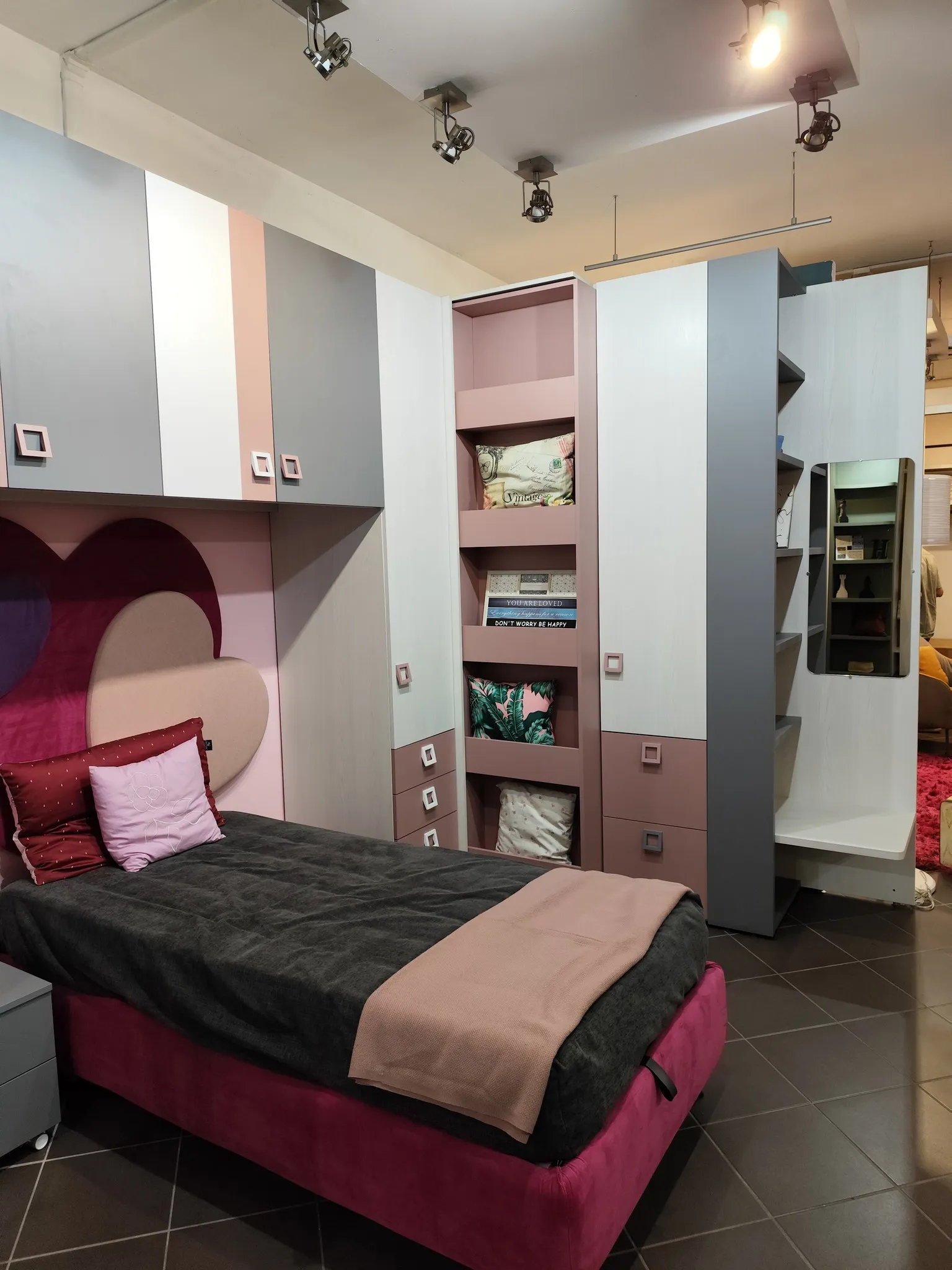 Camera legno naturale con letto blu e libreria