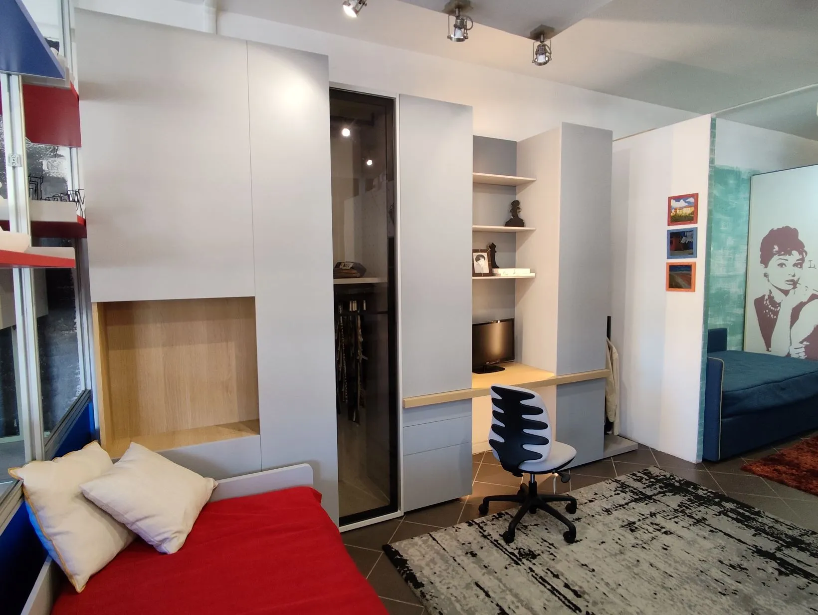 Camera con letto rosso, cabina armadio e scrivania