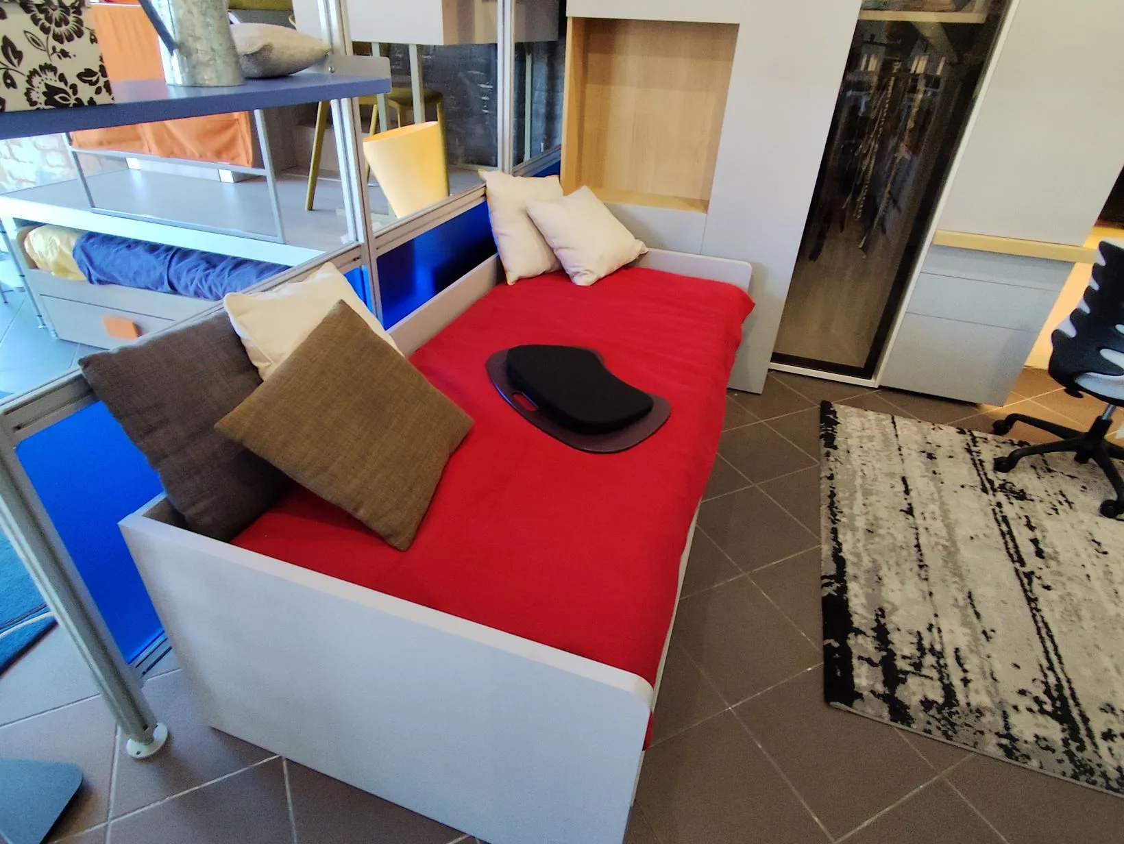 Letto rosso contenitore con cuscini bianchi