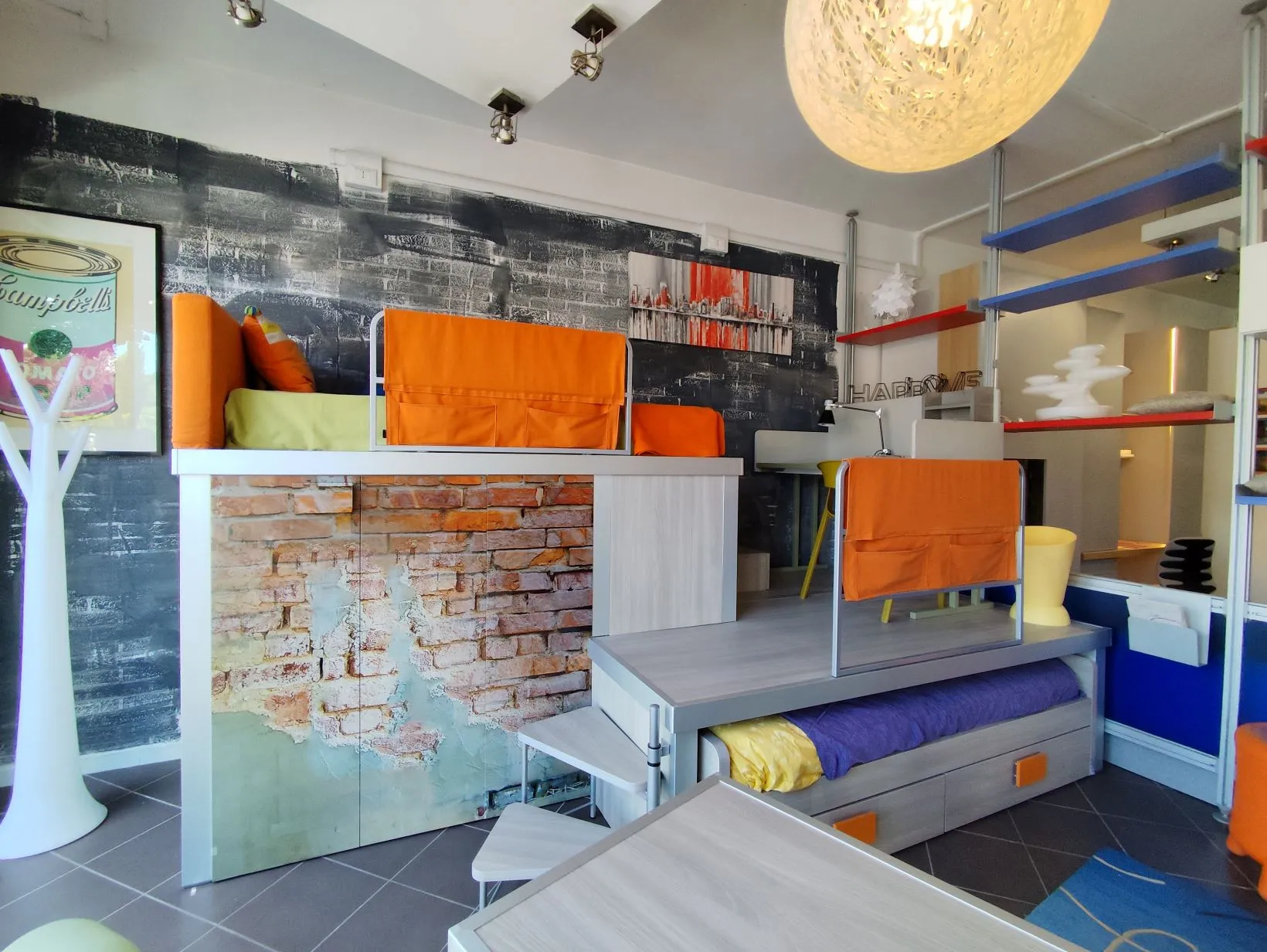 Soppalco industrial con muro mattoni e letti arancio