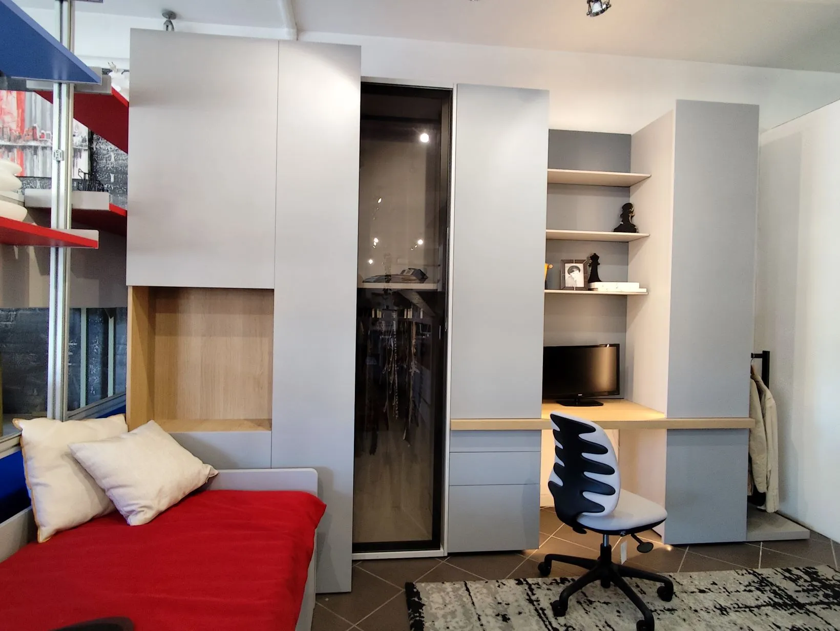 Zona studio grigia con libreria e cabina armadio